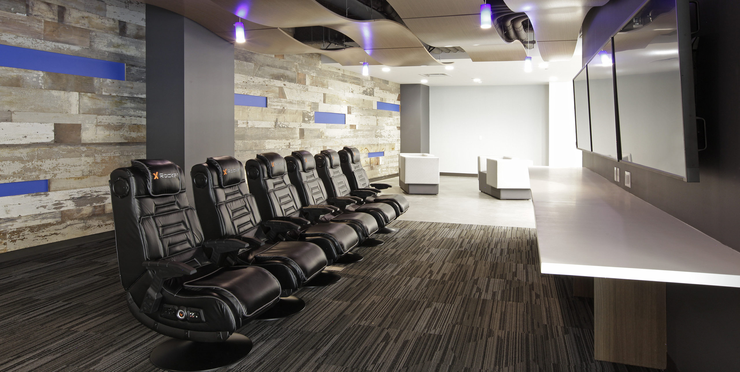 Gaming chairs in front of TVs at Dealertrack Technologies