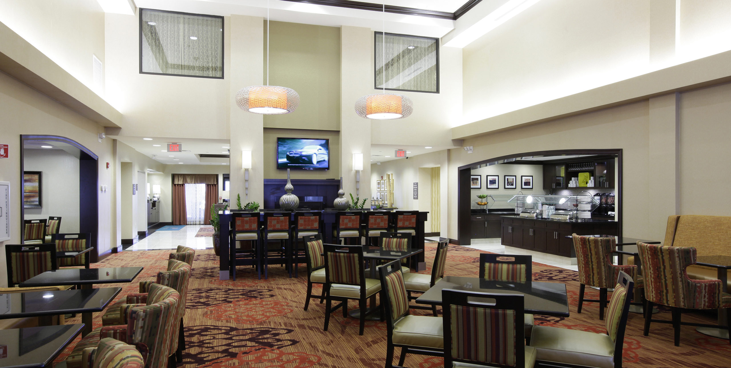 Lobby seating of four chairs to a table with couches at Homewood Suites in Carle Place