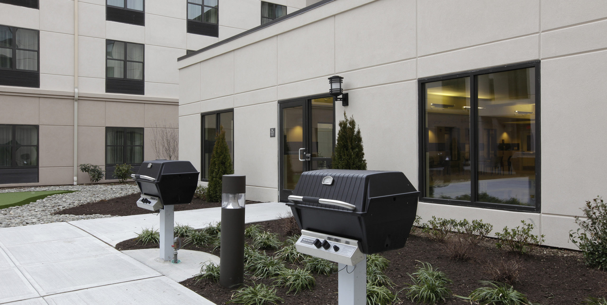 Exterior of Homewood Suites with two grills