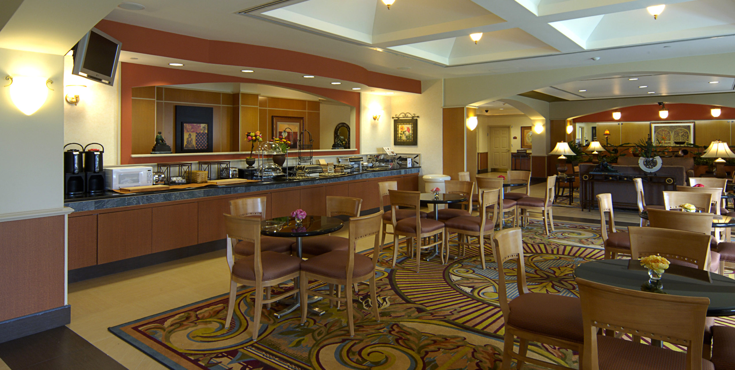 Dining room tables with four chairs at each table at La Quinta Inn and Suites by Wyndham Islip at 10 Aero Road, Bohemia