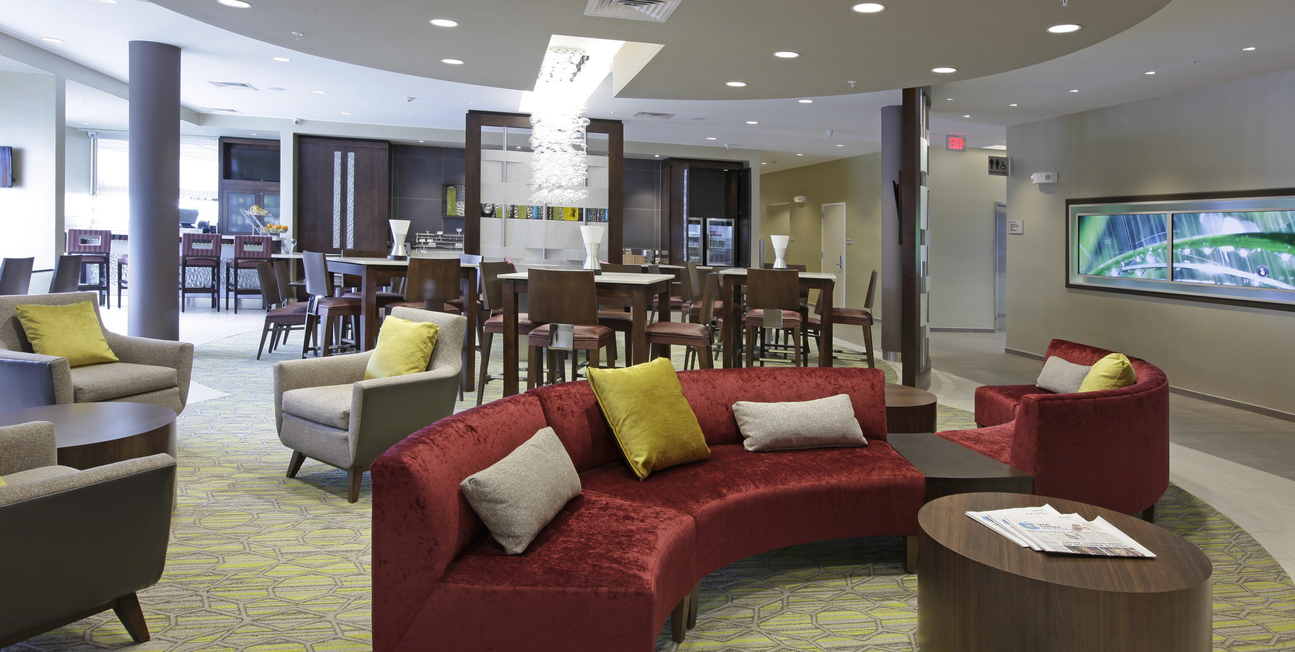 Lobby area with various couches, chairs, and tables at Spring Hill Suites by Marriott in Carle Place