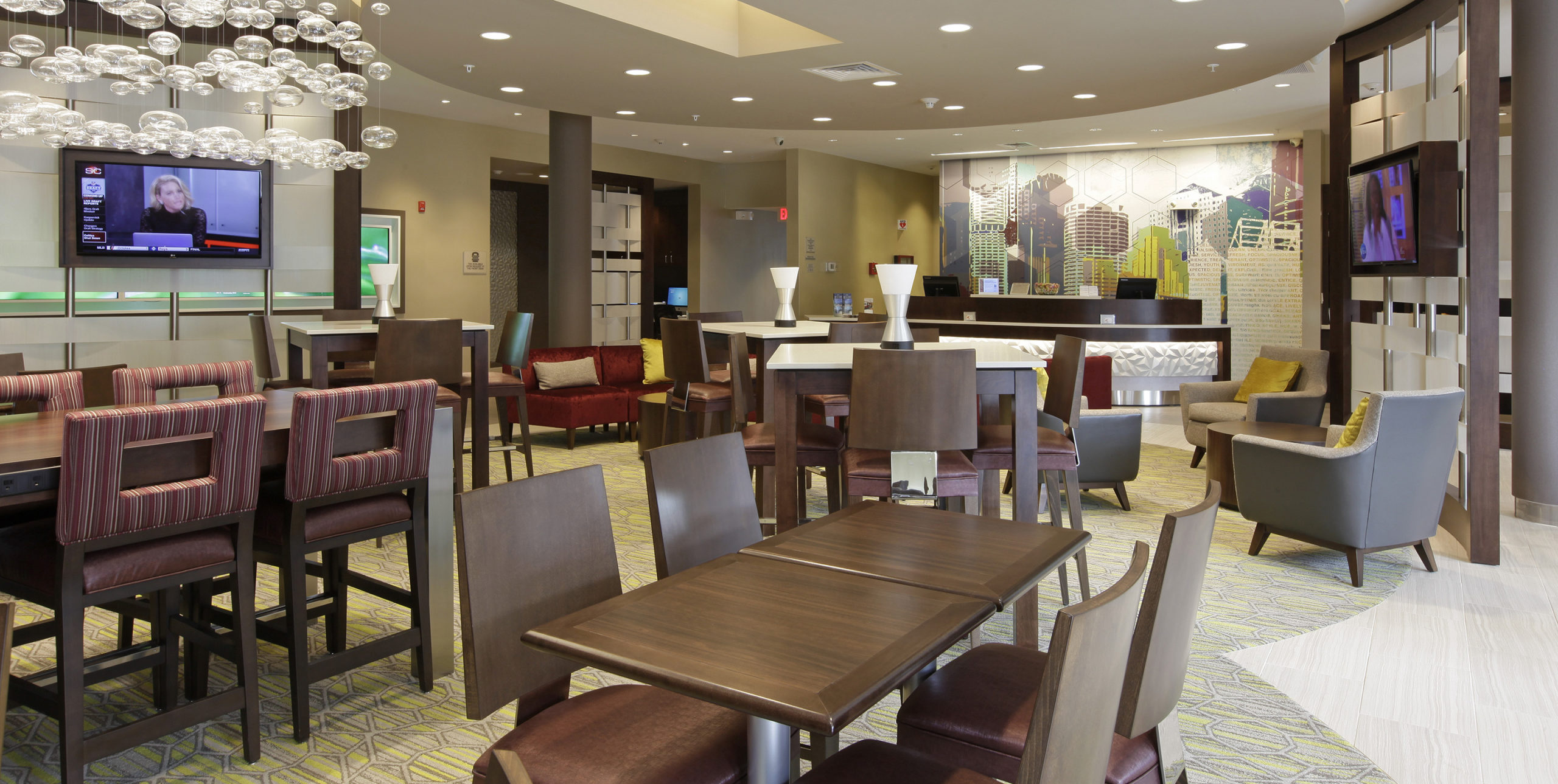 Indoor common seating with various chairs and tables at Spring Hill Suites by Marriott in Carle Place