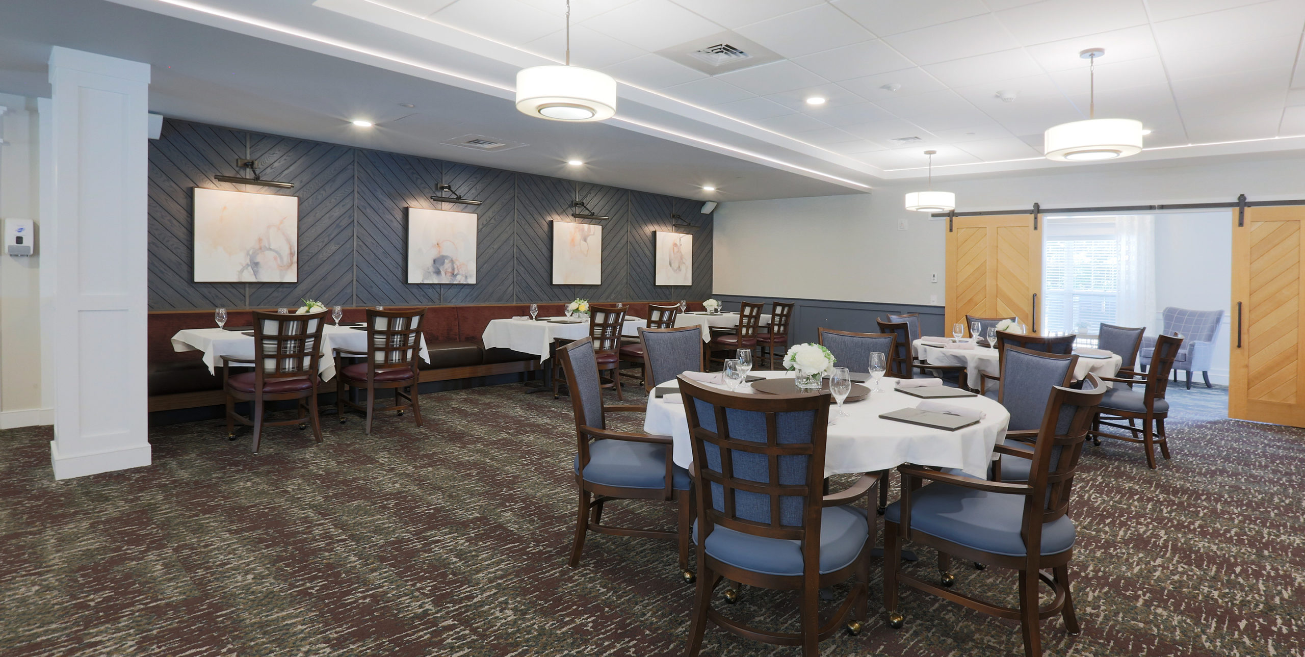 Dining room tables with six chairs at each table at Brightview Senior Living in Sayville, NY