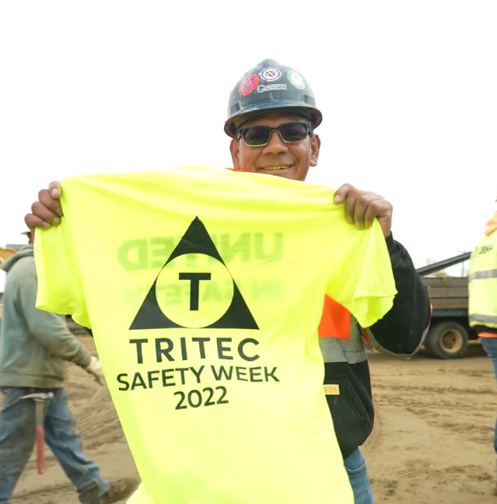 Subcontractor holding up a TRITEC Safety Week 2022 t-shirt