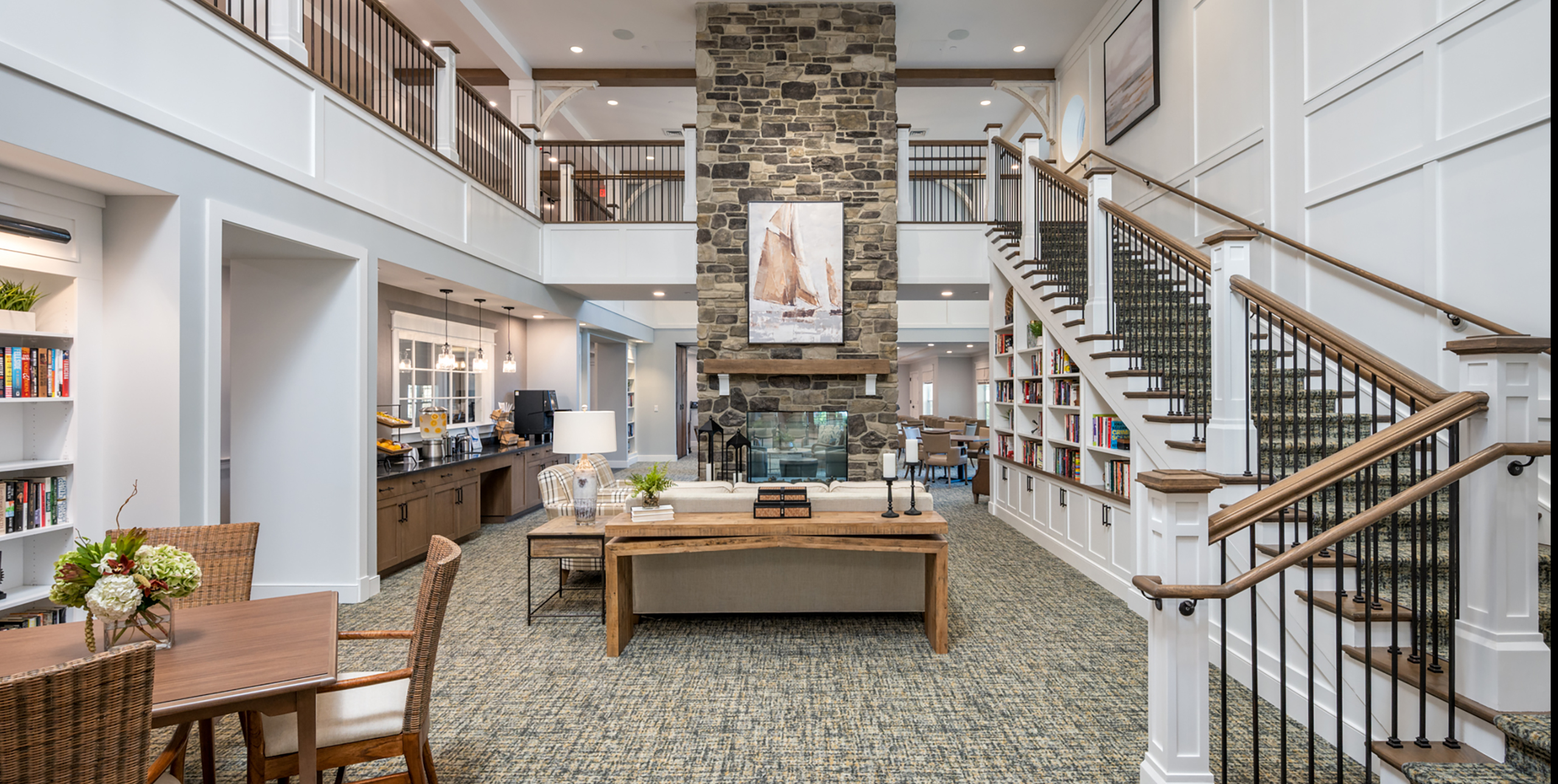 The grand staircase and fireplace in the common area at Brightview Senior Living Port Jeff