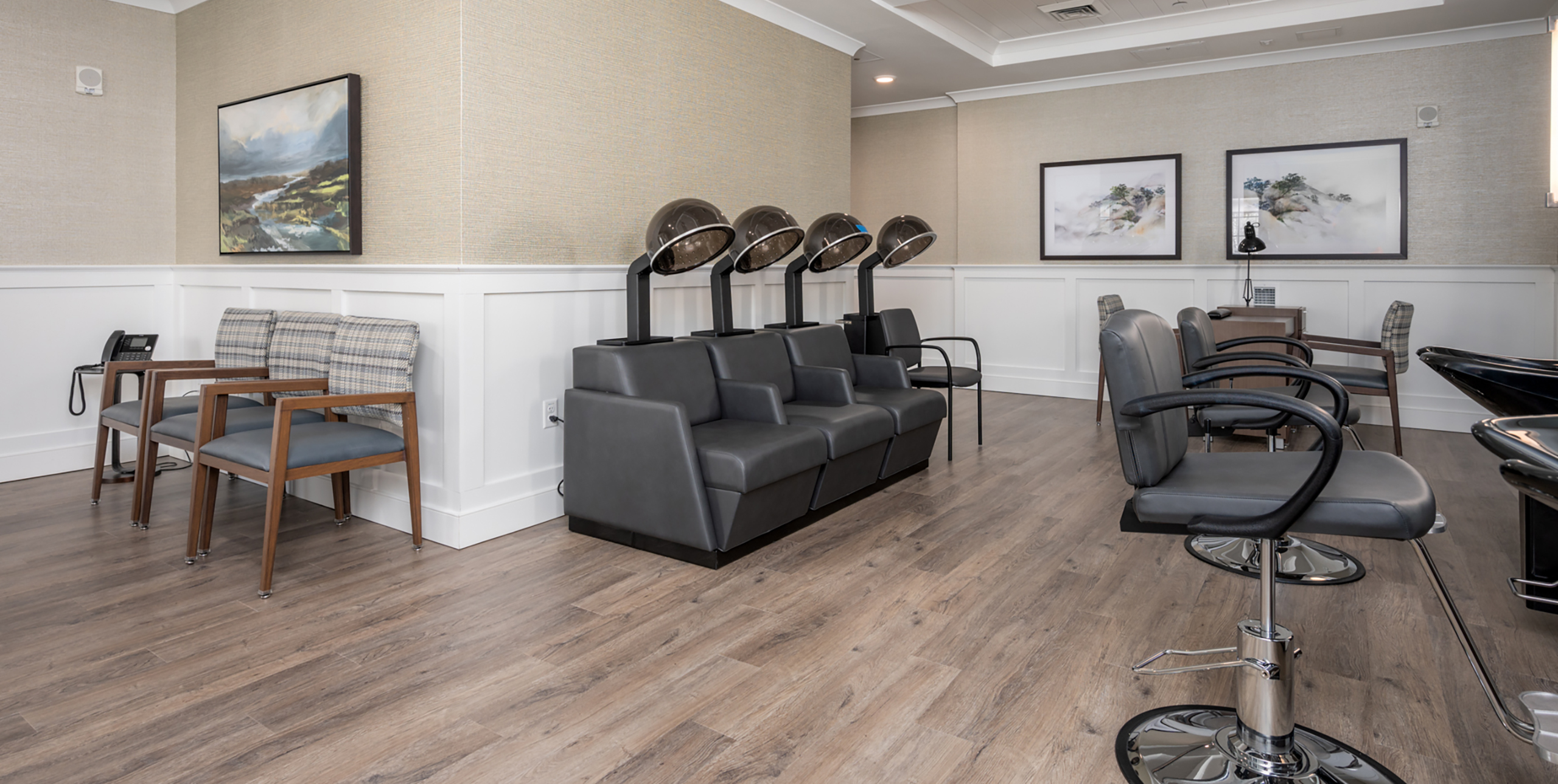 Seats with hair dryers and salon chairs in the salon at Brightview Senior Living Port Jeff