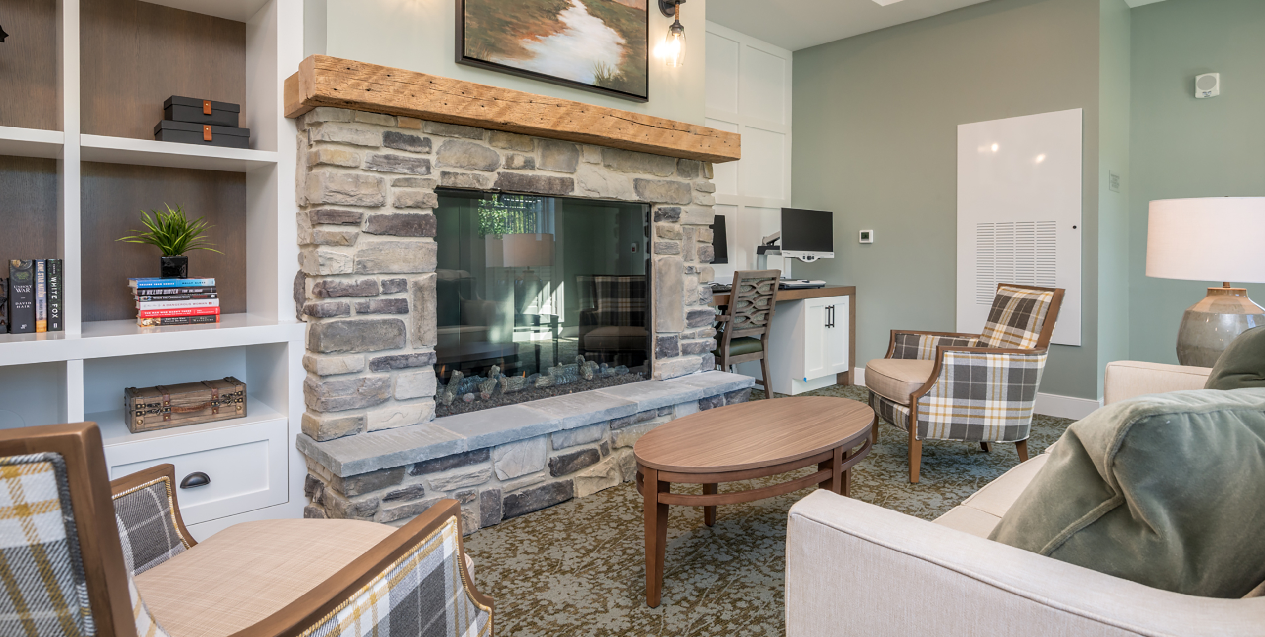Common living room area with a heatless fireplace at Brightview Senior Living Port Jeff