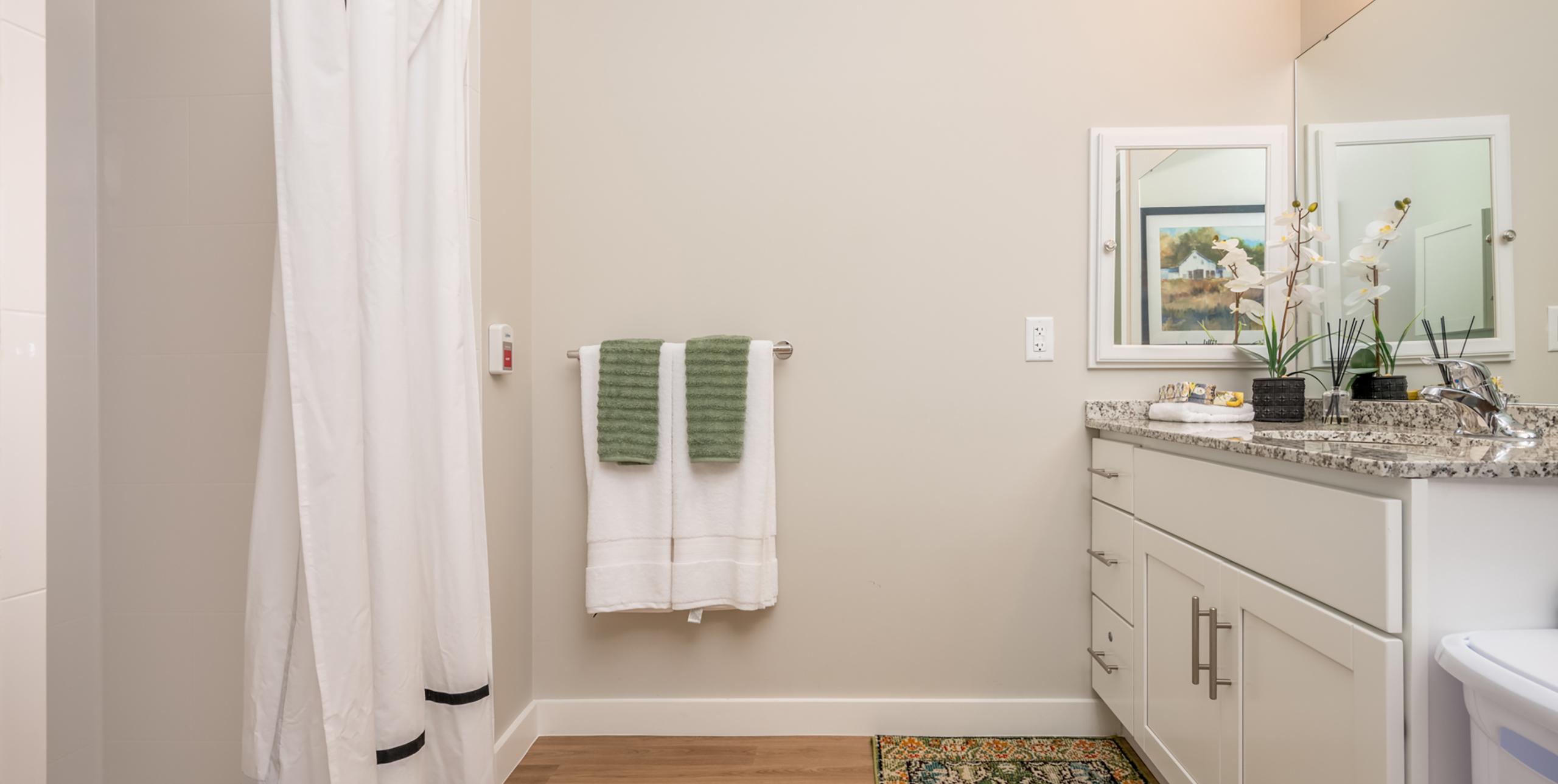 Bathroom with sink, shower, towels and curtains at Brightview Senior Living Port Jeff